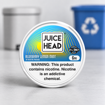 Juice Head Blueberry Lemon Mint 6mg nicotine pouch can in front of recycling bins.